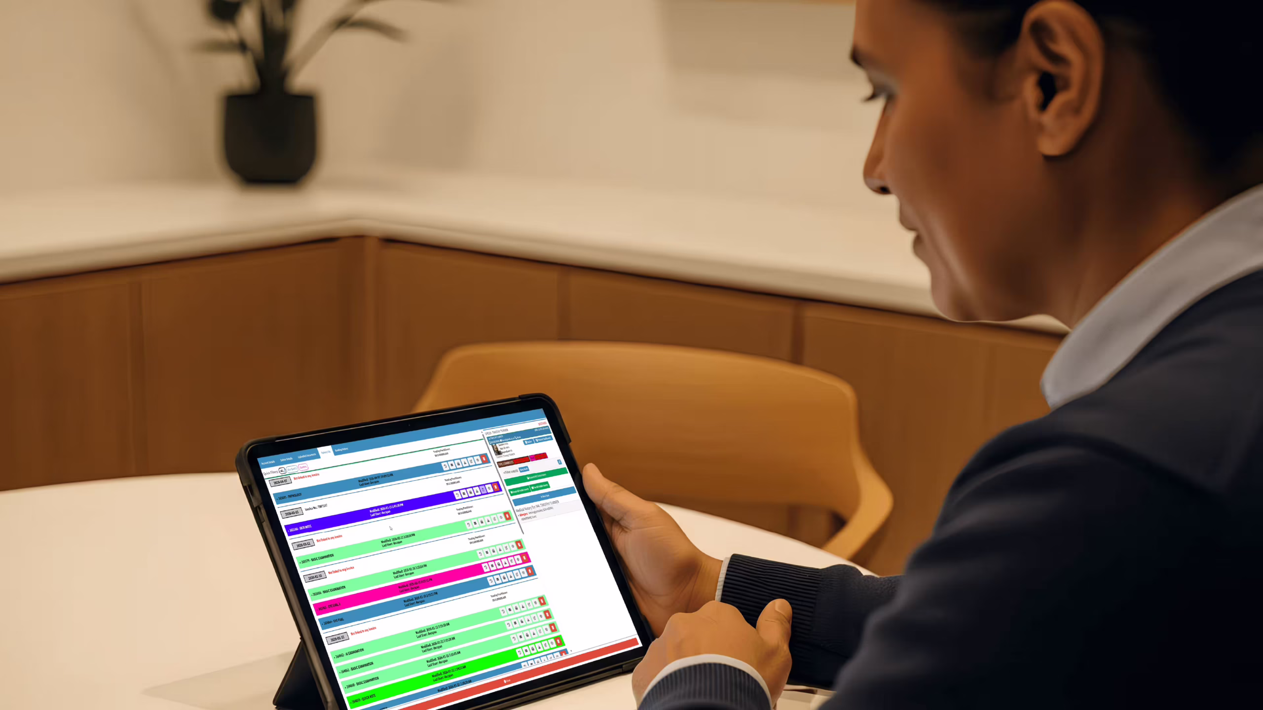 New Zealand GP reviewing EHR systems benefits on tablet in modern consultation room